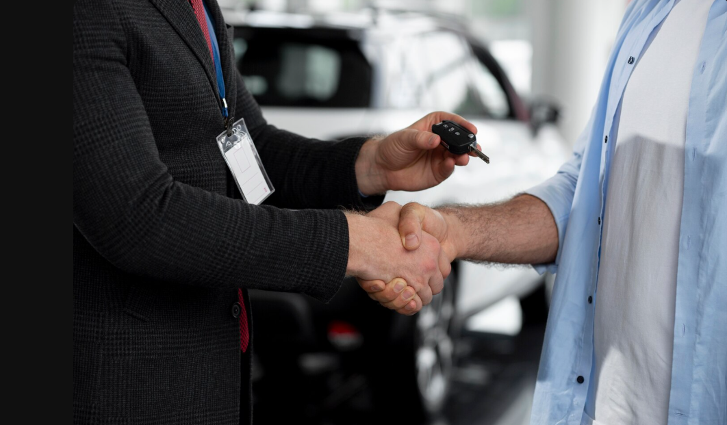 Un vendedor de GARBAT Automotores en Tandil estrecha la mano de un cliente que acaba de comprar un auto usado en Tandil y le entrega las llaves de su nuevo auto, simbolizando una venta exitosa.